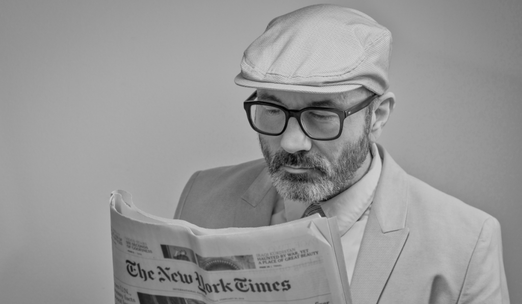 Man in glasses reading newspaper