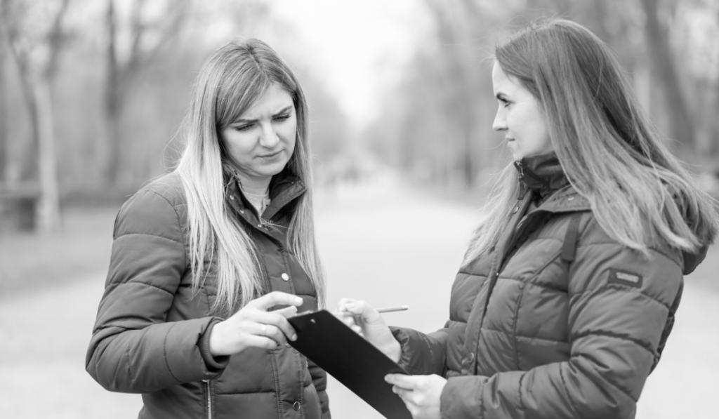 A woman interviewing another woman on the street